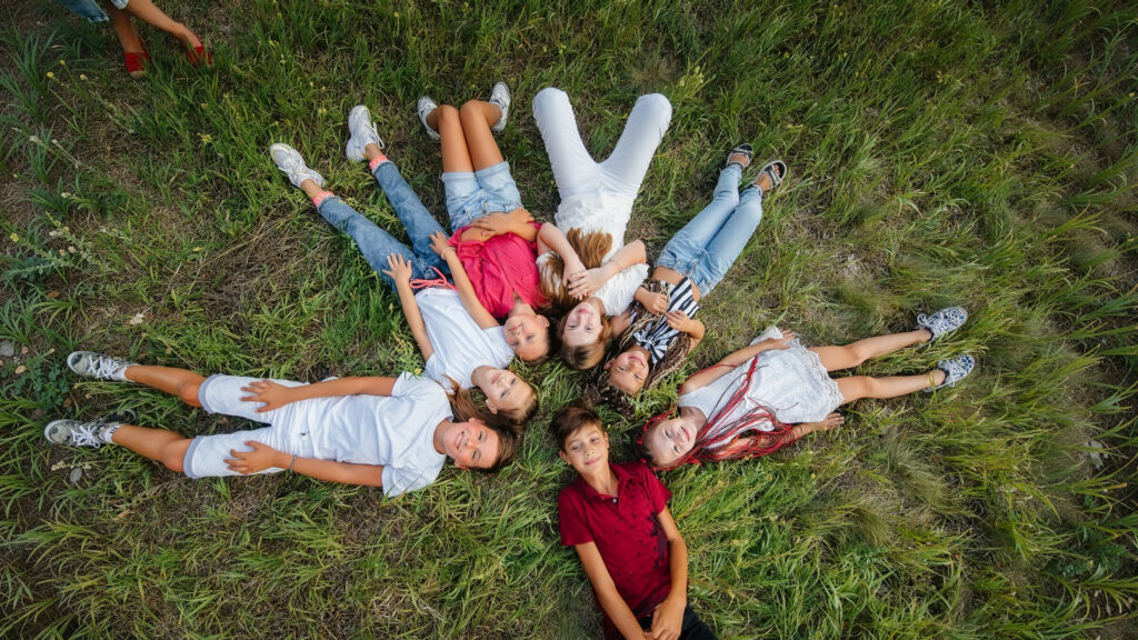 Un gruppo di ragazzi sdraiati sul prato, vista ortogonale